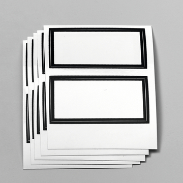 Das Bild zeigt mehrere identische, unbedruckte Papieretiketten mit schwarzen Rahmen. Diese Etiketten eignen sich für Beschriftungen und sind ideal für den Einsatz im schulischen Experimentierbedarf.