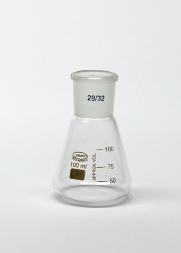 Das Bild zeigt einen messbecherartigen Erlenmeyer mit einem Fassungsvermögen von 100 ml. Er ist aus klarem Glas gefertigt und enthält Markierungen zur Volumenanzeige sowie einen speziellen Stopfen.