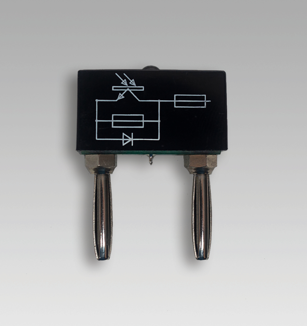 Das Bild zeigt ein elektrisches Bauteil mit zwei Anschlüssen und einer grafischen Darstellung von Schaltkreisen auf der Oberseite. Es scheint Bestandteil eines Experimentierkits für den Physik- oder Elektrotechnikunterricht zu sein.