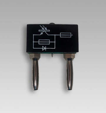 Das Bild zeigt ein elektrisches Bauteil mit zwei Anschlüssen und einer grafischen Darstellung von Schaltkreisen auf der Oberseite. Es scheint Bestandteil eines Experimentierkits für den Physik- oder Elektrotechnikunterricht zu sein.