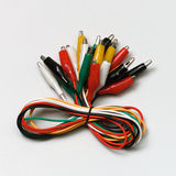 Das Bild zeigt eine Ansammlung von bunten Krokodilklemmen, die zum Verbinden von elektrischen Schaltkreisen verwendet werden. Diese Klemmen ermöglichen eine einfache und flexible Durchführung von Experimenten im Bildungsbereich.
