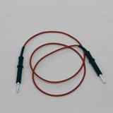 Das Bild zeigt ein Experimentierkabel mit einem orangefarbenen Draht und schwarzen Kunststoffanschlüssen an beiden Enden. Es ist typisches Zubehör für elektrische Experimente im Bildungsbereich.