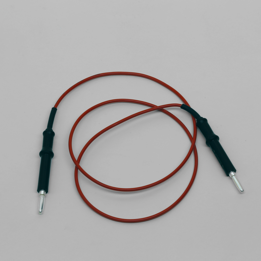 Das Bild zeigt ein Experimentierkabel mit einem orangefarbenen Draht und schwarzen Kunststoffanschlüssen an beiden Enden. Es ist typisches Zubehör für elektrische Experimente im Bildungsbereich.