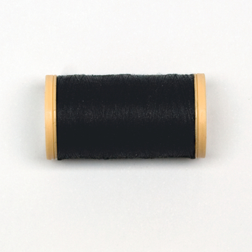 Das Bild zeigt eine Spule mit schwarzem Faden, die auf einer weißen Oberfläche liegt. Die Spule hat an beiden Enden gelbe Plastikkappen, die den Faden halten und schützen.