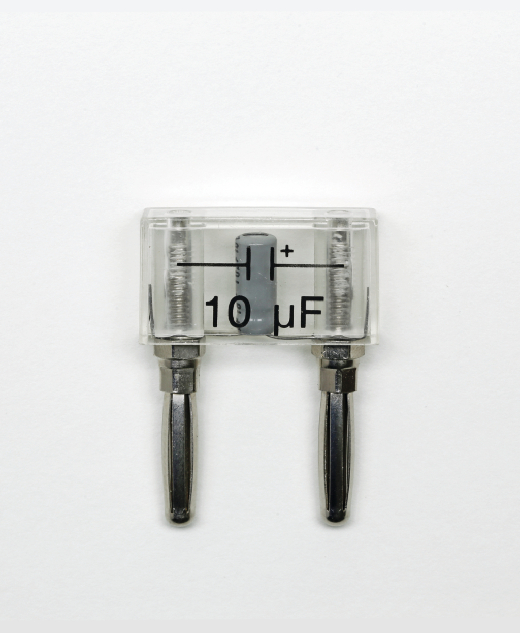 Das Bild zeigt einen Kondensator mit einer Kapazität von 10 μF, der in einem transparenten Gehäuse untergebracht ist. Die beiden Anschlussleitungen sind deutlich erkennbar und der Kondensator ist positiv markiert.