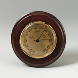 Das Bild zeigt ein Barometer mit einem eleganten Holzrahmen und einer goldenen Skala. Es ist mit Symbolen für Wetterbedingungen wie Sonne und Wolken gestaltet und misst den Luftdruck in Millibar.