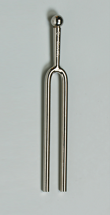Das Bild zeigt ein Stahlgabel-Tonmittel, das aus einem langen, geschwungenen Metallrohr besteht, das oben mit einer kleinen Kugel endet. Es wird häufig in der Musikausbildung verwendet, um die Tonhöhe zu bestimmen und als Stimmgerät zu dienen.
