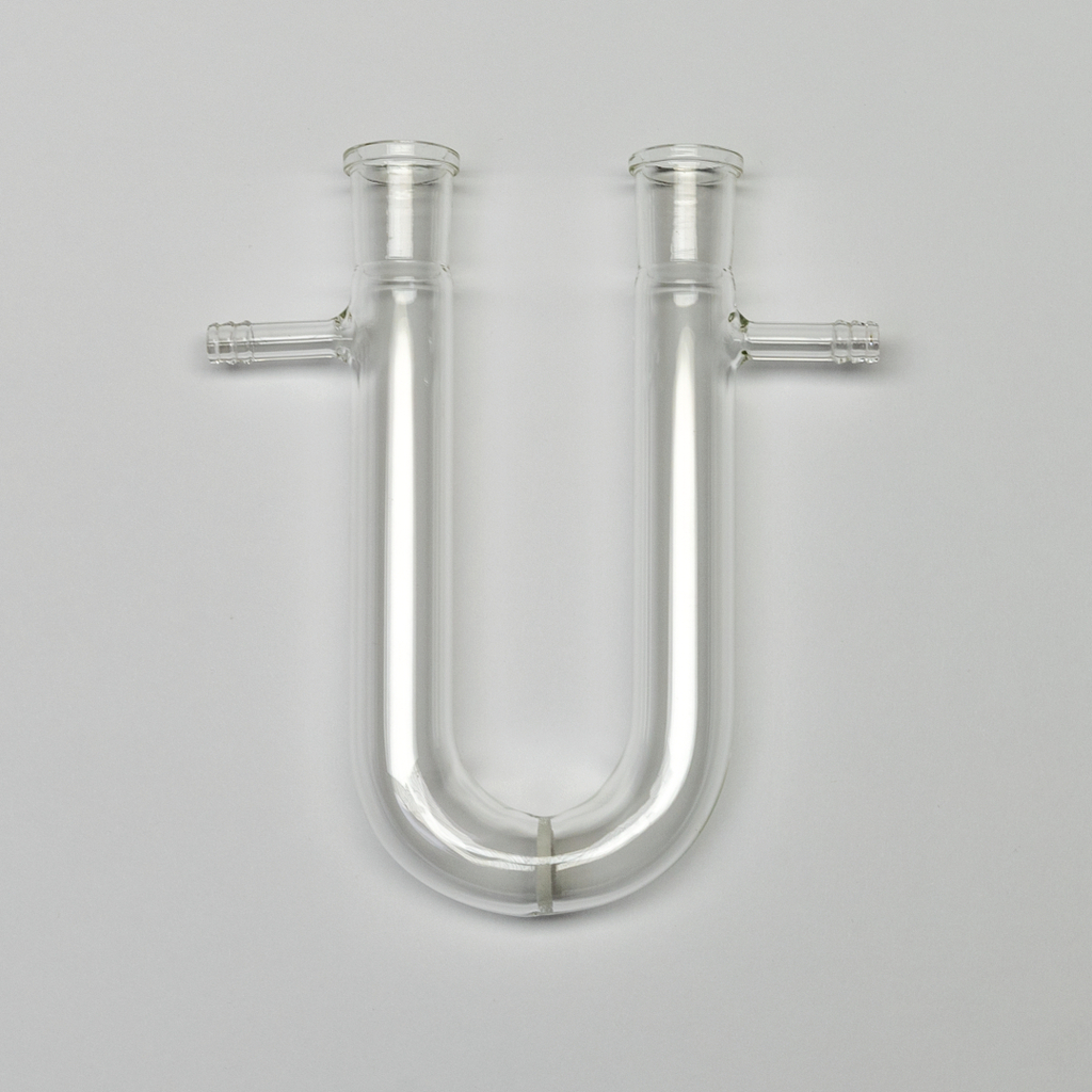 Das Bild zeigt ein U-förmiges Glasgerät mit zwei seitlichen Anschlüssen. Es wird häufig in chemischen Experimenten verwendet, um verschiedene Flüssigkeiten oder Gase zu leiten.