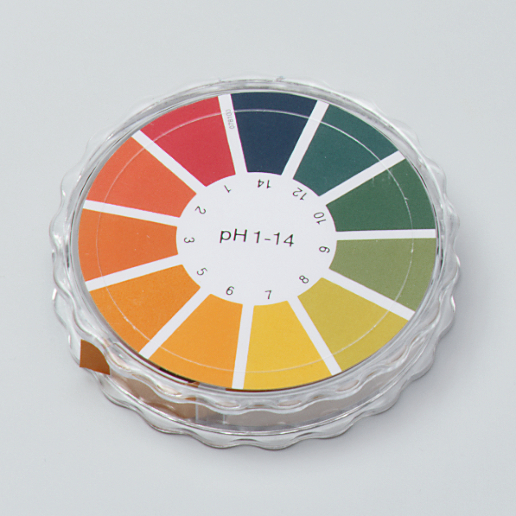 Das Bild zeigt eine pH-Farbtabelle in einem runden Behälter, die 14 verschiedene Farbtöne von rot bis grün abdeckt. Die Tabelle dient zur Bestimmung des pH-Werts von Lösungen im Bildungsbereich und ist ein praktisches Werkzeug für chemische Experimente.