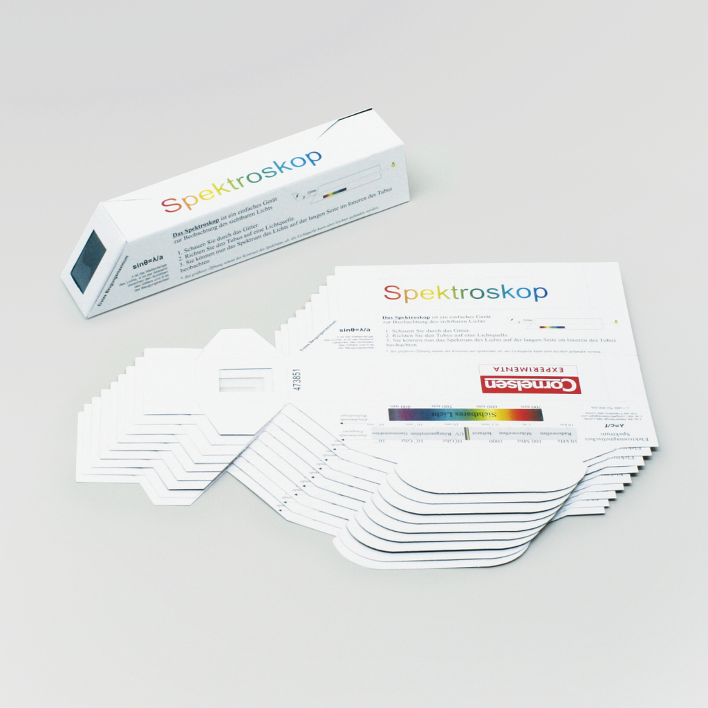 Das Bild zeigt ein Spektroskop in einer rechteckigen Verpackung sowie mehrere probenartige Karten mit Farbskalen und Erklärungen. Das Produkt dient als einfaches Gerät zur Analyse von Licht und Farben im Bildungsbereich.