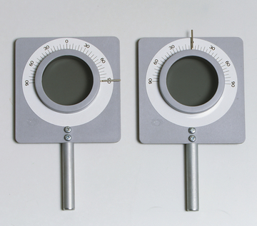 Das Bild zeigt zwei Messinstrumente, die jeweils eine runde Linse und eine Skala mit Werten von 0 bis 90 zeigen. Diese Geräte sind wahrscheinlich für experimentelle Zwecke im Bildungsbereich konzipiert, um Winkel oder Intensität zu messen.