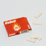 Das Bild zeigt eine Scheckkarte mit der Aufschrift "Esbit" und einer Illustration von Flammen. Neben der Verpackung liegen mehrere weiße, rechteckige Brenntabletten, die als fester Brennstoff für Kochen und Wärmen verwendet werden.