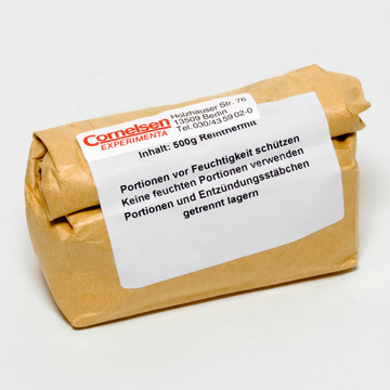 Das Bild zeigt ein Paket mit dem Inhalt von 500 g Reinmetall, das sorgfältig in braunes Papier gewickelt ist. Auf dem Etikett sind wichtige Hinweise zur Lagerung und Handhabung, insbesondere zum Schutz vor Feuchtigkeit und zur Trennung von entzündlichen Materialien, abgedruckt.