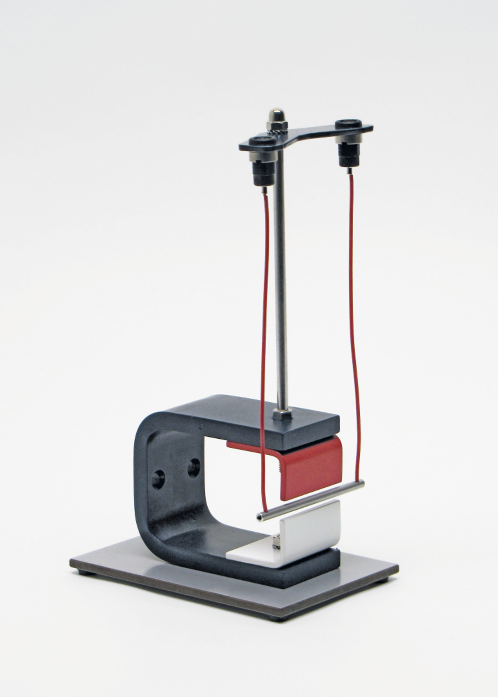 Das Bild zeigt ein Experimentiergerät, das aus einem stabilen Standfuß und einem vertikalen Halter besteht, an dem zwei Drähte befestigt sind. Es könnte zur Durchführung von physikalischen Experimenten, möglicherweise im Bereich der Elektromagnetismus, verwendet werden.