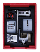 Das Bild zeigt ein Experimentierkit, das in einem roten Behälter angeordnet ist. Es enthält verschiedene technische Komponenten, darunter einen Motor, Kabel, Halterungen und weiteres Zubehör für Bildungsprojekte.