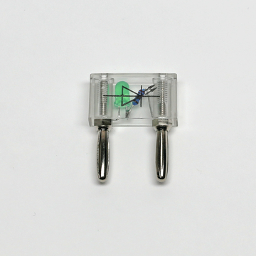 Das Bild zeigt ein transparentes elektrisches Experimentiergerät mit zwei Metallanschlüssen. Im Inneren sind eine grüne LED, ein Widerstand und eine Diode sichtbar, die typischerweise für Bildungszwecke verwendet werden.