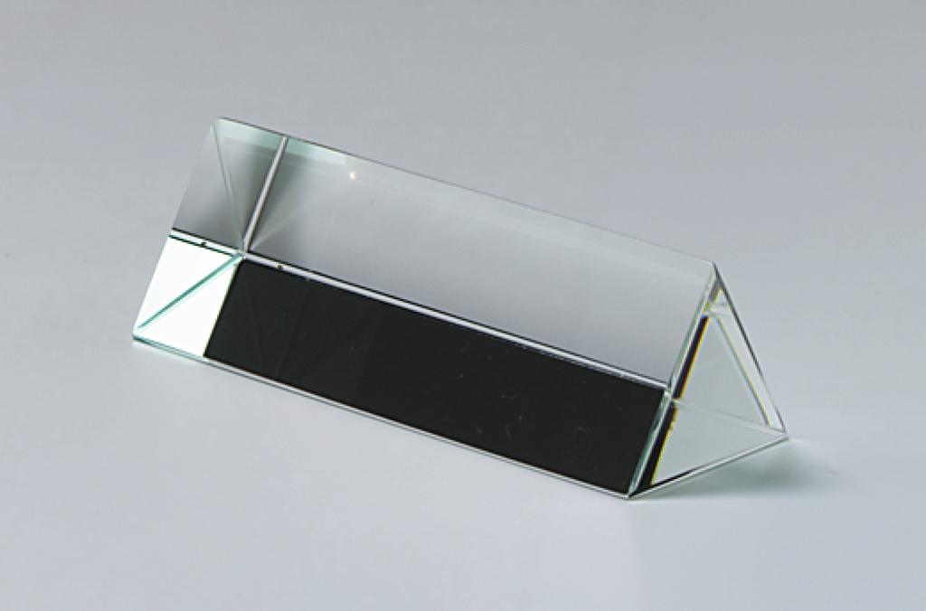 Das Bild zeigt einen transparenter, prismatischen Kristall mit einer trapezförmigen Basis. Er wird häufig im Bildungsbereich verwendet, um Lichtbrechung und andere optische Phänomene zu demonstrieren.