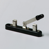 Das Bild zeigt einen mechanischen Schalter, der aus einer schwarzen Basis mit zwei Metallkontakten und einem Hebel besteht. Der Hebel scheint zur Aktivierung oder Deaktivierung von elektrischen Schaltungen verwendet zu werden, was für Experimente im Bildungswesen nützlich ist.