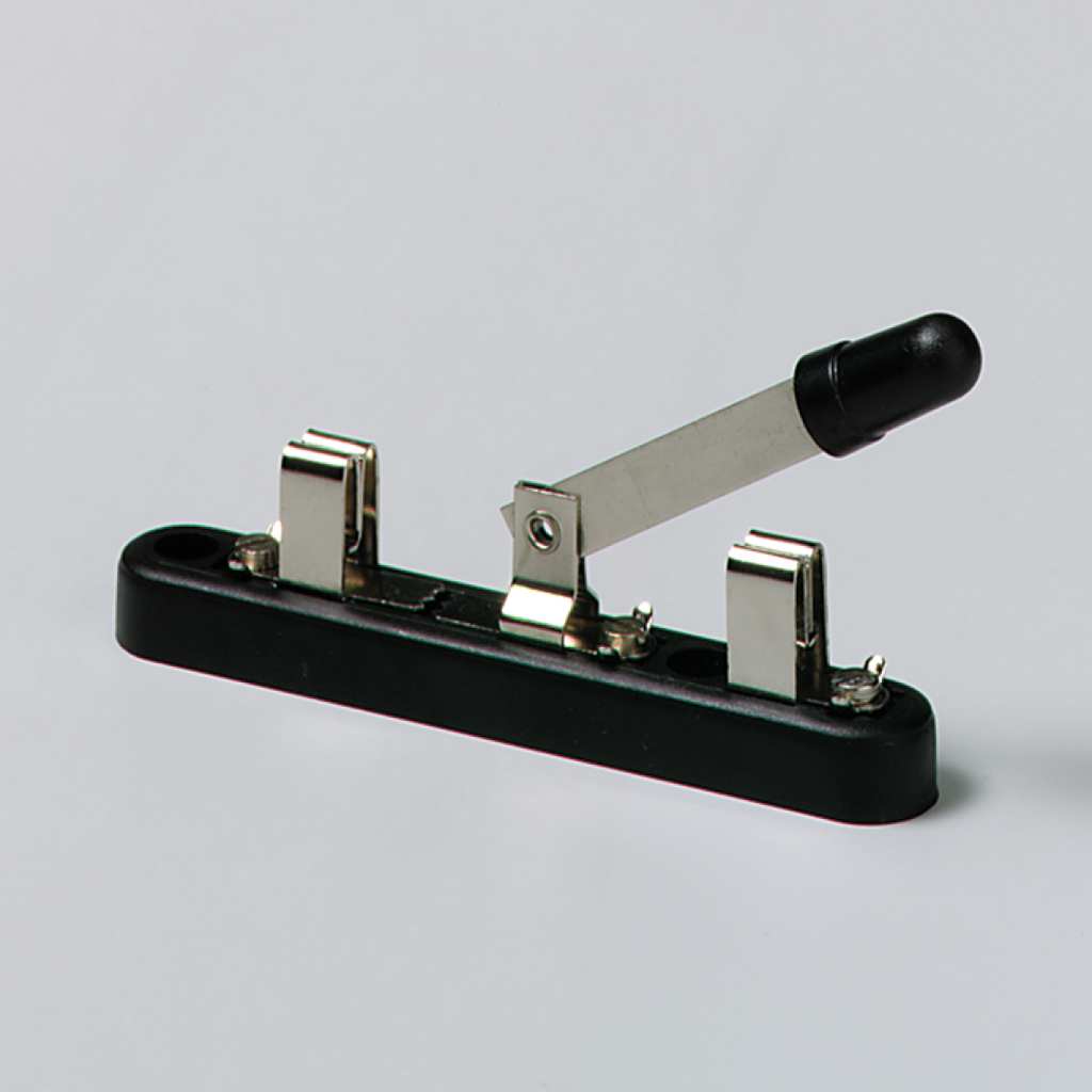 Das Bild zeigt einen mechanischen Schalter, der aus einer schwarzen Basis mit zwei Metallkontakten und einem Hebel besteht. Der Hebel scheint zur Aktivierung oder Deaktivierung von elektrischen Schaltungen verwendet zu werden, was für Experimente im Bildungswesen nützlich ist.