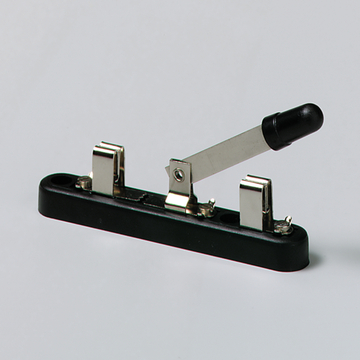 Das Bild zeigt einen mechanischen Schalter, der aus einer schwarzen Basis mit zwei Metallkontakten und einem Hebel besteht. Der Hebel scheint zur Aktivierung oder Deaktivierung von elektrischen Schaltungen verwendet zu werden, was für Experimente im Bildungswesen nützlich ist.