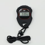 Das Bild zeigt einen digitalen Stoppuhr, Schwarz mit roten Akzenten, die präzise Zeiten messen kann. Sie verfügt über mehrere Tasten für Funktionen wie Start, Stopp und Zurücksetzen, und ist mit einem praktischen Band ausgestattet.