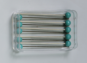 Das Bild zeigt ein Set von Stäben mit kugelförmigen Enden, die in einem transparenten Behälter aufbewahrt sind. Diese Materialien sind wahrscheinlich für experimentelle Zwecke im Bildungsbereich konzipiert.