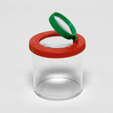 Das Bild zeigt einen transparenten Behälter mit einem roten Deckel und einer grünen Lupe. Der Behälter dient zur Aufbewahrung und Untersuchung von Objekten, ideal für schulische Experimente und Bildungszwecke.