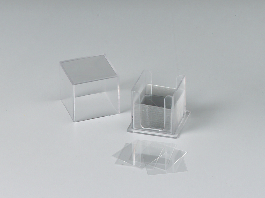 Das Bild zeigt einen transparenten Behälter mit dazugehörigen Objektträgern. Der Behälter ist geöffnet und enthält mehrere dünne Platten, die für experimentelle Zwecke im Bildungswesen verwendet werden.