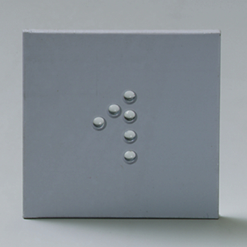 Das Bild zeigt eine graue Fläche mit mehreren kleinen, runden Objekten, die in einer bestimmten Anordnung platziert sind. Diese Objekte könnten Bestandteil eines Experimentierkits für den Bildungsbereich sein, möglicherweise zur Untersuchung physikalischer Phänomene.