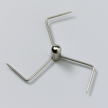 Das Bild zeigt ein metallisches Experimentiergerät in Form eines Sterns mit vier abgewinkelten Drahtarmen, die von einer zentralen Kugel ausgehen. Es wird vermutlich im Bildungswesen für verschiedene chemische oder physikalische Experimente eingesetzt.