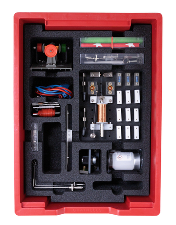 Das Bild zeigt ein Experimentierkasten mit verschiedenen Komponenten, darunter Motoren, Drähte und Messinstrumente, alle sorgsam in einem roten Kunststoffbehälter angeordnet. Der Kasten ist für den Einsatz in Schulen konzipiert und fördert praktisches Lernen in Naturwissenschaften.