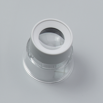 Das Bild zeigt eine Lupe mit einem klaren Kunststoffgehäuse und einer runden Linse. Diese Lupe eignet sich für Experimentierzwecke im Bildungsbereich, um Objekte zu vergrößern und Details zu beobachten.