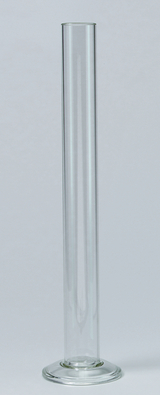 Das Bild zeigt ein hohes, klares Reagenzglas mit einem stabilen, runden Fuß. Es wird häufig im Bildungsbereich für chemische Experimente und Darstellungen von Lösungen verwendet.