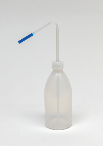 Das Bild zeigt eine durchsichtige Kunststoffflasche mit einem langen, gebogenen Ausguss, der an der Spitze blau gefärbt ist. Diese Flasche wird typischerweise für Labor- oder Experimentierzwecke verwendet, um Flüssigkeiten präzise zu dosieren.