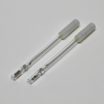 Das Bild zeigt zwei Glasröhren mit einem transparenten, isolierenden Ende. Diese Röhren werden vermutlich für experimentelle Anwendungen im Bildungsbereich verwendet, möglicherweise im Bereich der Chemie oder Physik.