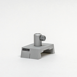 Das Bild zeigt einen grauen Experimentieraufbau aus einem Online-Shop für Bildungseinrichtungen. Er besteht aus einer stabilen Basis mit einem vertikalen Röhrchen und Drehknopf, vermutlich zur Durchführung chemischer Experimente.