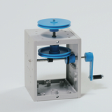 Das Bild zeigt ein Experimentiergerät mit zwei blauen Rollen und einem Handgriff, das in einem weißen Gehäuse montiert ist. Es dient wahrscheinlich zur Demonstration physikalischer Prinzipien wie der Mechanik oder der Kräfteübertragung im Bildungsbereich.