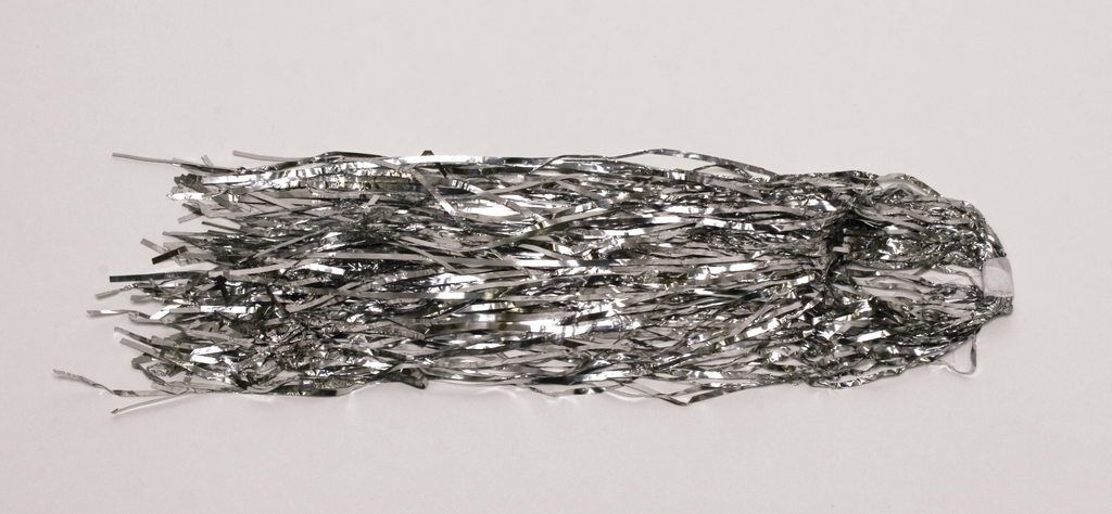 Das Bild zeigt eine Menge silberner, glänzender Fransen, die lose angeordnet sind. Diese könnte als Dekoration oder für experimentelle Zwecke im Bildungsbereich verwendet werden.