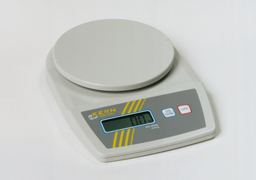 Das Bild zeigt eine digitale Laborwaage von KERN, Modell EMB 220-I, mit einem runden Wiegebehälter auf der oberen Fläche. Die Anzeige ist klar und zeigt den aktuellen Gewichtswert, während die Waage für einfache Tarierung und Bedienung ausgestattet ist.