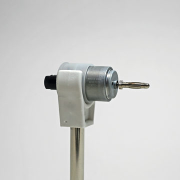 Das Bild zeigt einen Elektromotor, der auf einem Metallständer montiert ist. Er ist Teil von Experimentierbedarf, der für schulische Bildungszwecke genutzt wird, um physikalische Konzepte wie Motorfunktion und Elektromagnetismus zu demonstrieren.