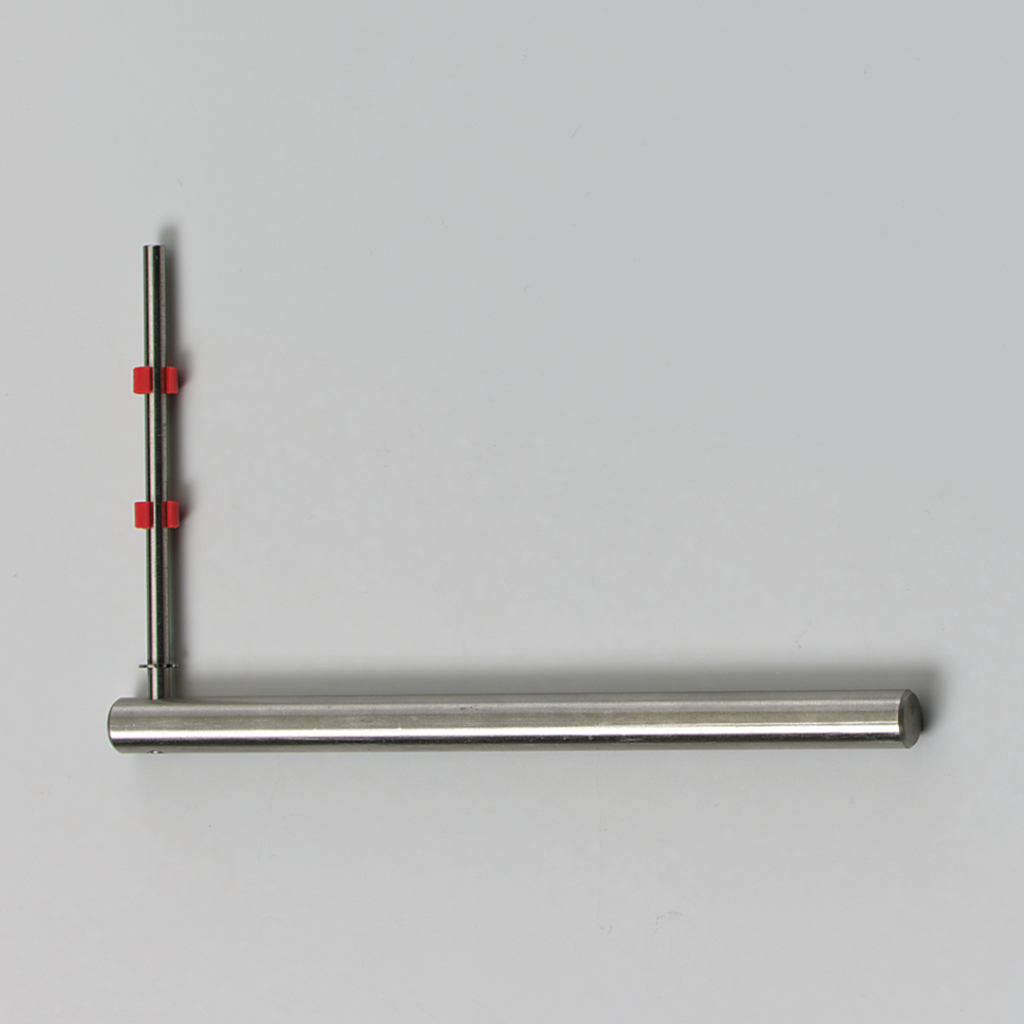 Das Bild zeigt ein experimentelles Gerät, das aus einem langen, geraden Metallrohr und einem vertikalen Stab besteht. Beide Teile sind mit roten Halterungen verbunden, die eine flexible Positionierung ermöglichen.