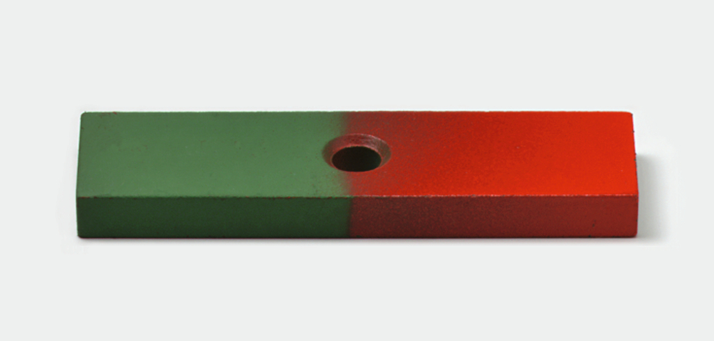 Das Bild zeigt einen rechteckigen Magneten, der halb grün und halb rot gefärbt ist, mit einem Loch in der Mitte. Er könnte im Bildungsbereich für Experimente zur Magnetkraft oder zur Demonstration von Magnetpolen verwendet werden.