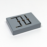 Das Bild zeigt ein graues Experimentiergerät mit mehreren Anschlüssen und einer schwarzen Leitungsführung auf der Oberfläche. Es ist wahrscheinlich für Bildungszwecke im naturwissenschaftlichen Bereich konzipiert.