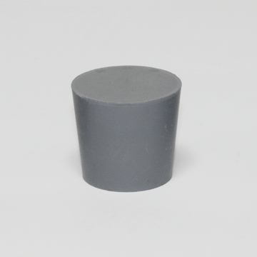 Das Bild zeigt einen grauen, zylindrischen Block aus Kunststoff mit einer flachen Oberseite. Dieses Experimentiermaterial könnte in verschiedenen wissenschaftlichen Anwendungen im Bildungsbereich verwendet werden.