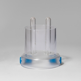 Das Bild zeigt ein Experimentiergerät mit zwei transparenten Röhren, die in einer runden Basis integriert sind. Es scheint für chemische oder physikalische Experimente im Bildungsbereich konzipiert zu sein.