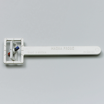 Das Bild zeigt einen weißen Kunststoffgegenstand namens "Magna Probe", der mit einem rechteckigen Ende und einem langen Griff ausgestattet ist. An dem Ende befinden sich zwei farbige Markierungen, die wahrscheinlich zur Messung oder Anzeige von Werten verwendet werden.