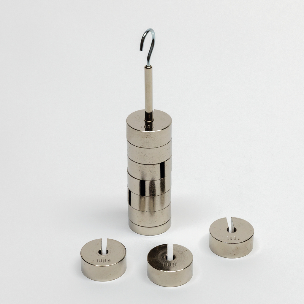 Das Bild zeigt einen Satz von Metallgewichten, die auf einem Hakenstapel angeordnet sind. Daneben befinden sich weitere runde Gewichte, die für Experimentierzwecke im Bildungsbereich verwendet werden können.