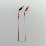 Das Bild zeigt einen elektrischen Draht mit zwei Anschlussklemmen, eine schwarz und die andere rot, die für Experimente verwendet werden können. Der Draht ist flexibel geformt und eignet sich für den Einsatz in Laboren oder Schulprojekten im Bildungsbereich.