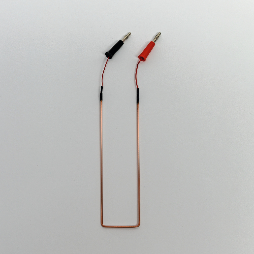 Das Bild zeigt einen elektrischen Draht mit zwei Anschlussklemmen, eine schwarz und die andere rot, die für Experimente verwendet werden können. Der Draht ist flexibel geformt und eignet sich für den Einsatz in Laboren oder Schulprojekten im Bildungsbereich.