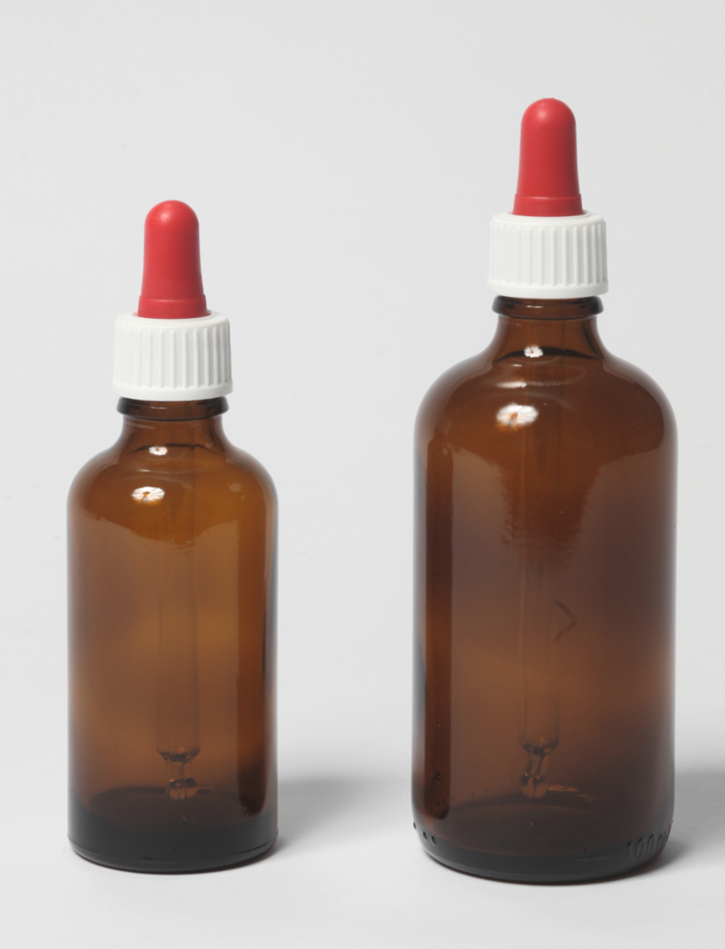 Das Bild zeigt zwei braune Glasflaschen mit roten Tropfaufsätzen. Die Flaschen unterscheiden sich in der Größe und sind typischerweise für die Aufbewahrung von Flüssigkeiten im experimentellen Bereich geeignet.